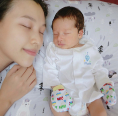 Hoàng Oanh lấy khăn che ngực trần khi đang xộc xệch không cài cúc cho con bú