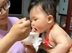 Bé gái yếm đỏ mũm mĩm đốn tim nhiều người vì háu ăn, giật cả bát từ tay mẹ